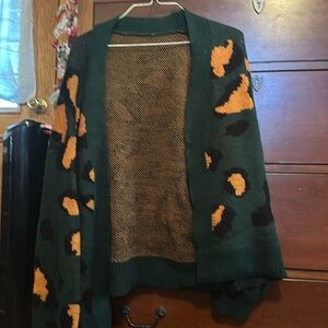 A Stylish dark green sweater with orange printed spots